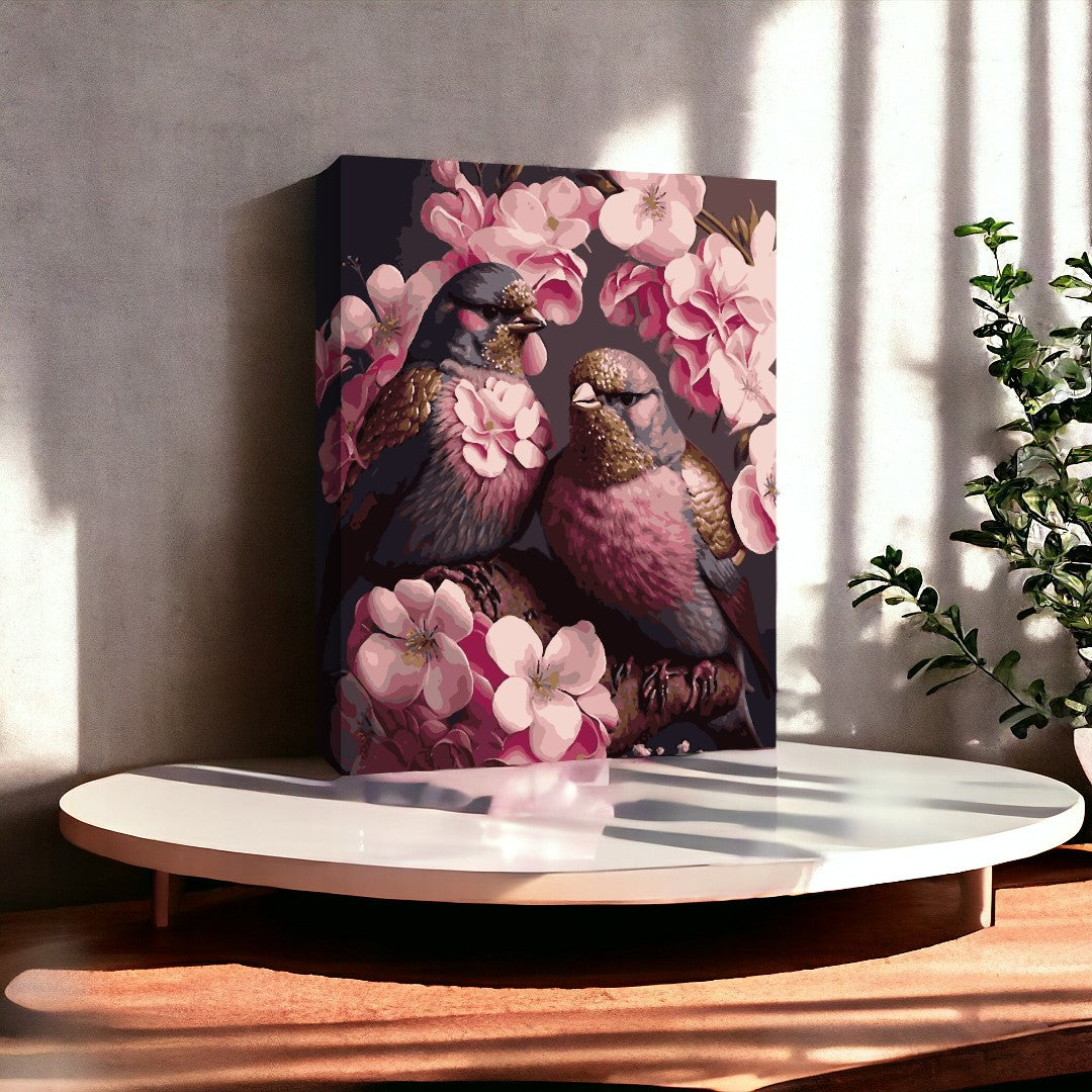 Le tableau représente deux oiseaux entourés de fleurs roses, placés sur une table ronde blanche dans un intérieur très éclairé.